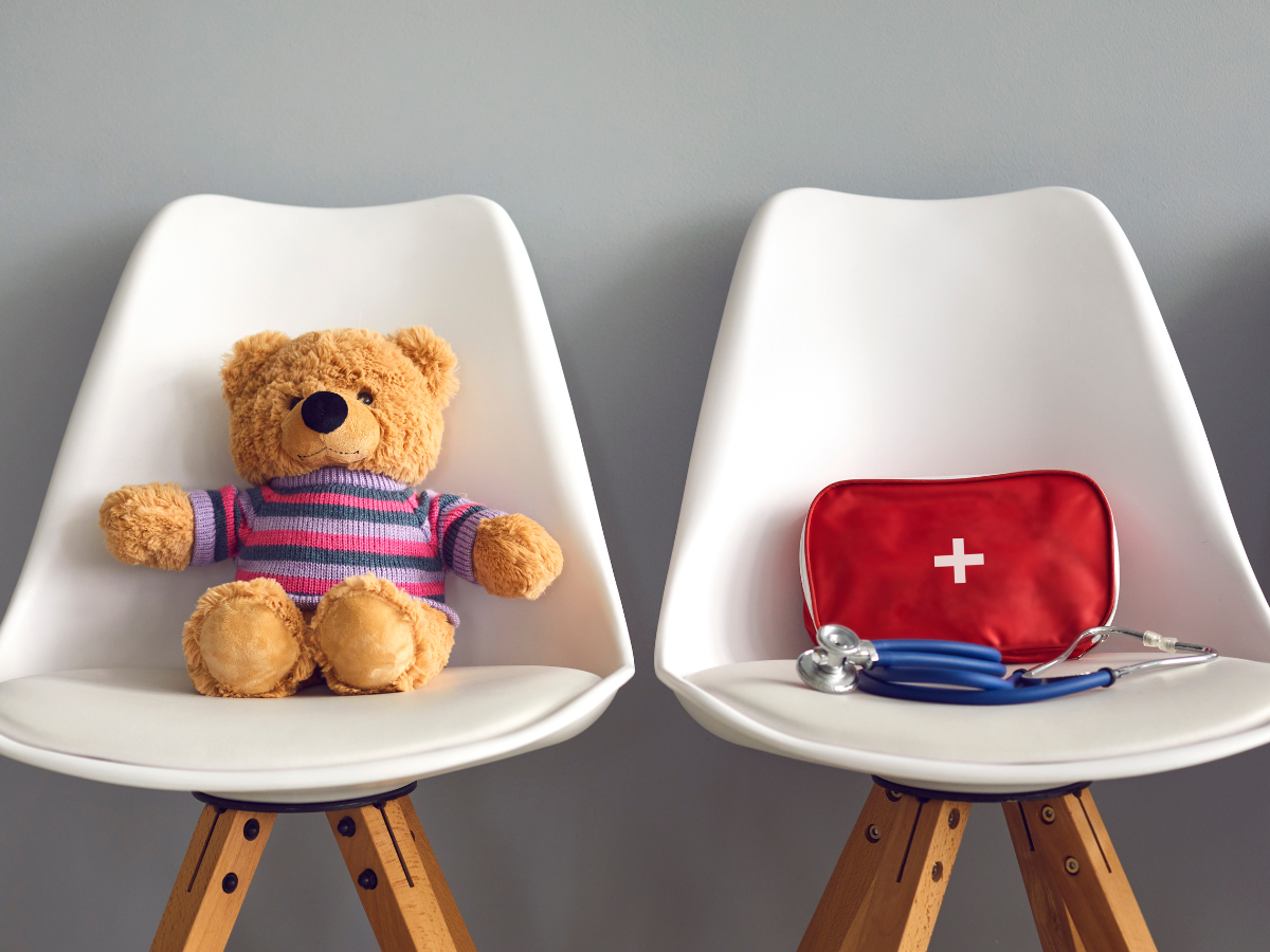 Pediatric readiness concept with teddy bear on chair and medical equipment on another chair next to it